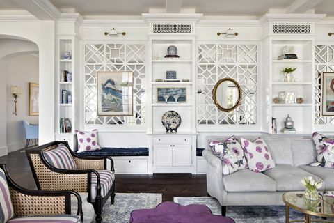 dnevna soba, siv kavč, vijolične in bele okrasne blazine, bele omare za shranjevanje, vijolični otoman