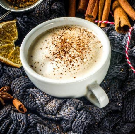 jesenska sladka vroča pijača, rum z maslom iz čaja, bučna pita ali bučna začimba kava latte prijetno jesensko ozadje s tradicionalno skodelico latte, začimbami in starim puloverjem na rustikalnem lesenem ozadju