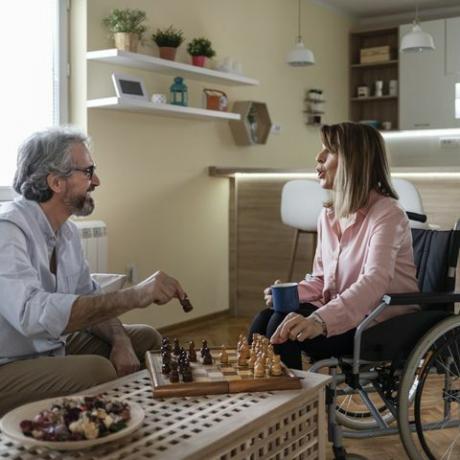 moški in ženska na invalidskem vozičku igrata šah