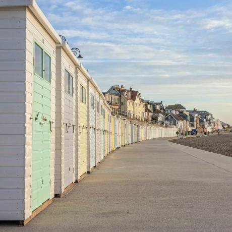 Koče na plaži v pastelnih barvah se vrstijo ob promenadi v mestu Lyme Regis, Dorset