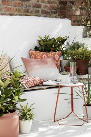 ideje za vrt, zunanji prostor za sedenje, napolnjen z blazinami, rastlinami in stransko mizico
