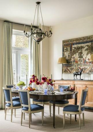 jedilnica, lesena ovalna jedilna miza, rože, modri in beli jedilni stoli