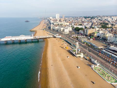 zračna fotografija znamenitega pomola in oceana Brighton, ki se nahaja na južni obali Anglije, ki je del mesta Brighton in Hove, posneta v svetlem sončnem dnevu, ki prikazuje vožnje po sejmišču