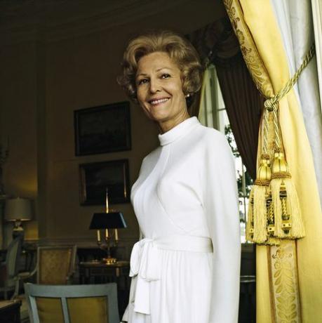 vogue, 15. oktober 1972 portret pat nixon nee thelma catherine patricia ryan prva dama Združenih držav in žena predsednika richarda milhousa nixona, ki stoji v rumeni ovalni sobi bele hiše ob rumeni zavesi, ki jo zadržujejo velike rese, nosi belo obleko z dolgimi rokavi, stoječim ovratnikom in pasom s pasom s kravato, pas horstconde nast via getty slike