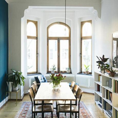 Lesena miza in stoli v moderni dnevni sobi z velikim okenskim sprednjim delom v elegantnem stanovanju