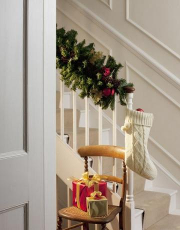 Božična darila in nogavice blizu stopnišča na hodniku