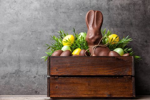 Tradicionalni velikonočni čokoladni zajček in jajca znotraj lesenega zaboja