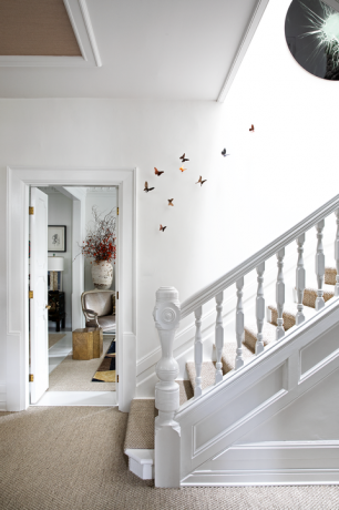 bela soba z skulpturami metuljev, ki se dvigajo po stopnicah