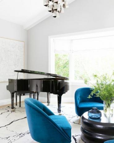 dnevna soba z velikim klavirjem in modrimi stoli