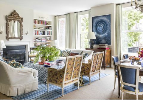 dnevna soba, sobne rastline, kamin, modra preproga, beli kavč s krilom, vgrajena v knjižno polico