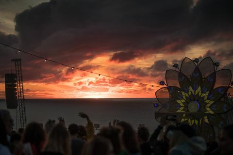 Newquay v Angliji 10. avgusta se ljudje zberejo ob sončnem zahodu na letnem glasbenem festivalu boardmasters v zalivu Watergate 10. avgusta 2018 v Cornwallu v Angliji od leta 1981, poteka tekmovanje v deskanju je potekal v newquayu in je zdaj del večjega petdnevnega vodstva deskanja, drsanja in glasbenega festivala, medtem ko na glasbenem festivalu množice v zalivu Watergate Bay surf tekmovanje privabi profesionalne deskarje z vsega sveta, da se pomerijo na obali Cornish, za katero mnogi menijo, da je rojstni kraj sodobnega britanskega deskarskega fotografiranja Matta Cardygettyja slike